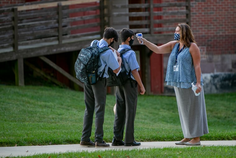 Students of the Doane Academy in Burlington, N.J. have their temperatures taken by Allison Trosko, director of transportation, before entering the school building on Tuesday.