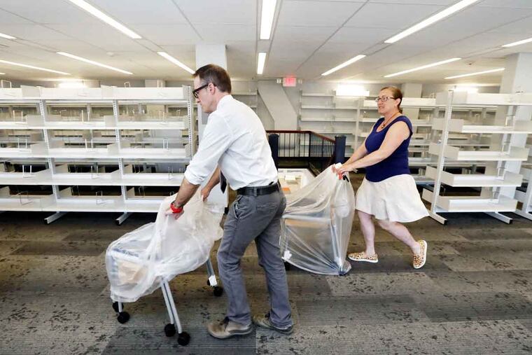 Haddonfield Public Library Director Eric Zino and Sharon Parker, library restoration project manger and interior design consultant, move new furniture into the newly renovated second level at the library.