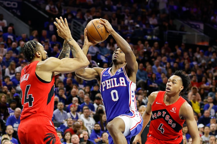 Sixers guard Tyrese Maxey drives to the basket against Toronto Raptors center Khem Birch (left) and forward Scottie Barnes during game one in the Eastern Conference quarterfinals playoffs on Saturday, April 16, 2022 in Philadelphia.