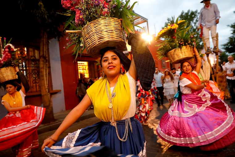 In Oaxaca, Mexico, dancers in jewel-tone gowns, each balancing a basket of roses on her head, were part of a "calenda" (parade) celebrating a milestone through the historic center of the city.