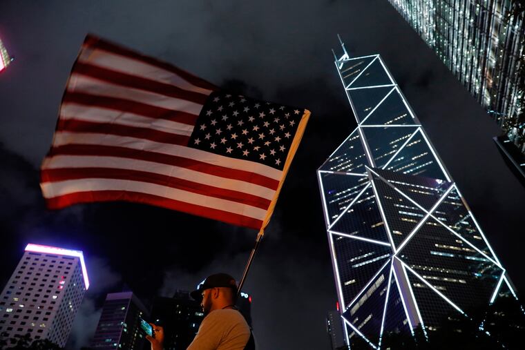 American Joey Gibson from Washington raises the American flag as he shows support at a rally by mothers for student protesters in Hong Kong on Friday, Jan. 5, 2019. The societal divide in Hong Kong showed no sign of closing Friday as students rebuffed an offer from city leader Carrie Lam to meet and a few thousand mothers rallied in support of the young protesters who left a trail of destruction in the legislature's building at the start of the week.