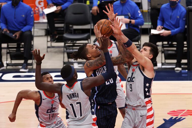 Markelle Fultz (20) shoots the ball as Washington Wizards forward Isaac Bonga (17) and Wizards forward Deni Avdija (9) defend on Dec 26.