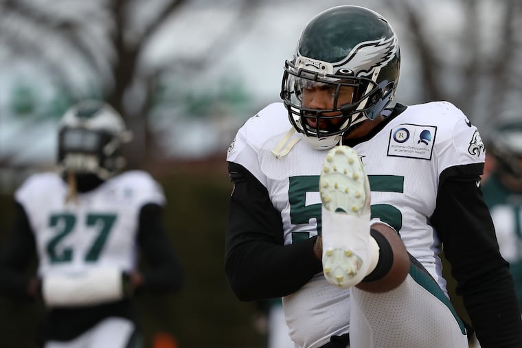 Eagles defensive end Brandon Graham kicks his leg as he warms up during Thursday's practice.