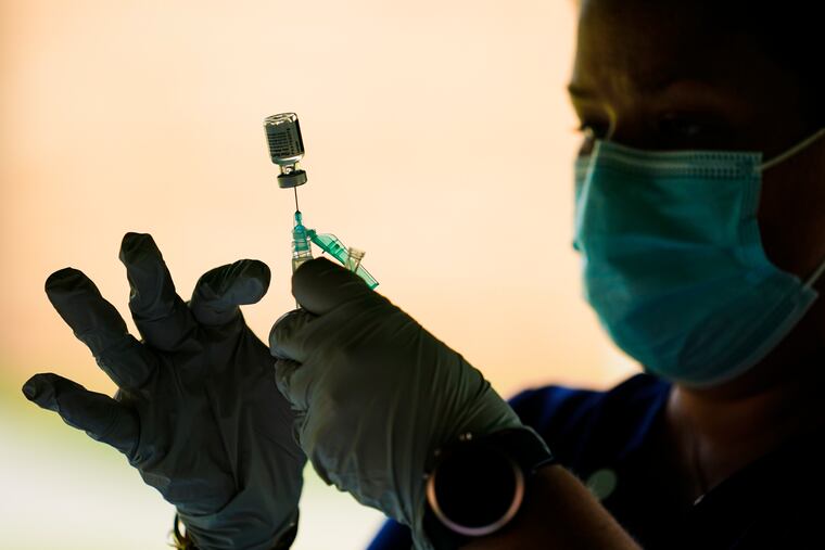 A syringe is prepared with the Pfizer COVID-19 vaccine at a clinic at the Reading Area Community College in Reading, Pa. Millions of U.S. workers now have a Jan. 4 deadline to get a COVID vaccine. The federal government on Thursday, Nov. 4, 2021 announced new vaccine requirements for workers at companies with more than 100 employees as well as workers at health care facilities that treat Medicare and Medicaid patients.