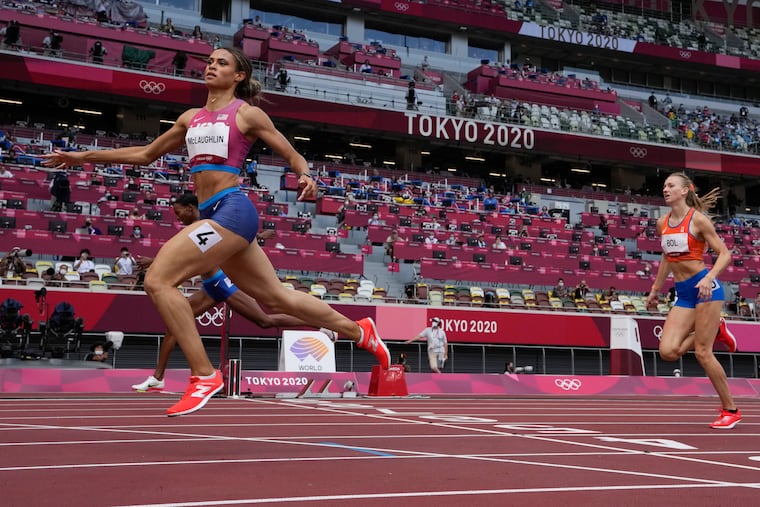 Sydney McLaughlin, left, crosses the finish line in the women's 400-meter hurdles final.