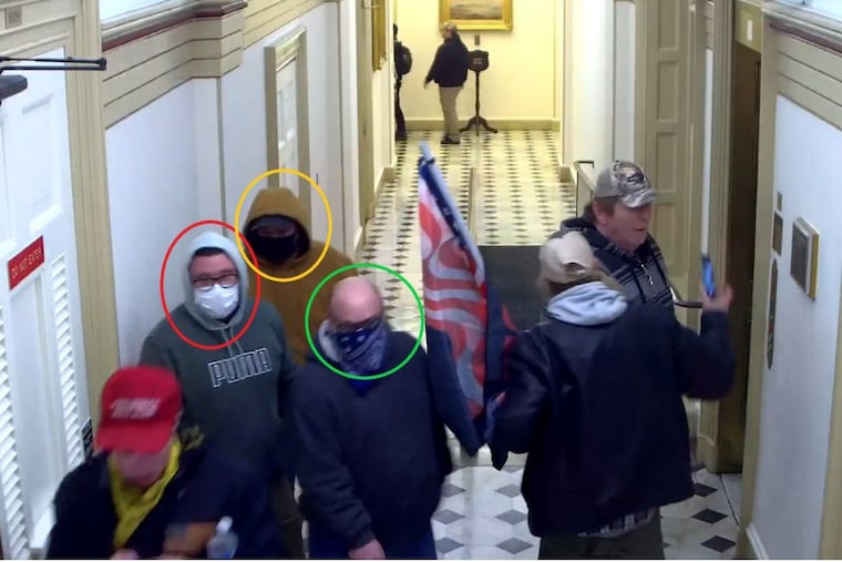 Security camera footage from the U.S. Capitol shows Nicholas Krauss (in green Puma hoodie), Russell Dodge (in gold hoodie), and David Krauss (wearing a bandana over his face) among the rioters who stormed the building during the Jan. 6, 2021, attack on Congress.
