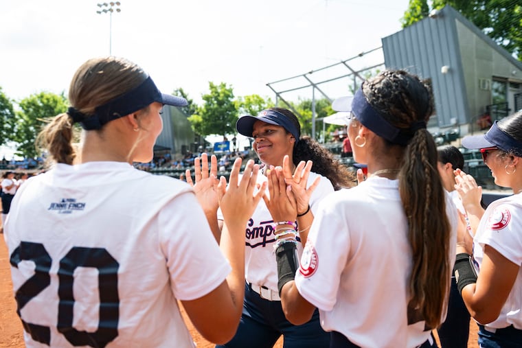 Players from the Compton Youth Academy high five before the start of the Jennie Finch Classic Championship Game at Penn Softball Field on Monday.