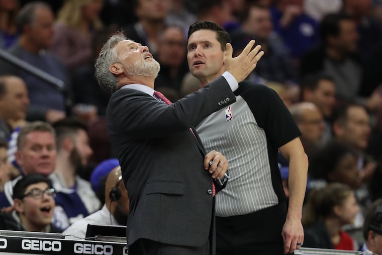 Brett Brown watches a replay as he complains about the Sixers being called for a lane violation against the Cavaliers.