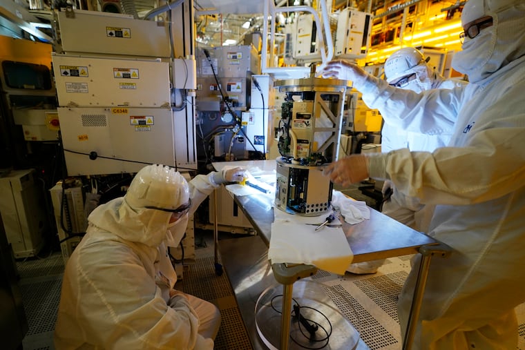 Technicians inspect a piece of equipment during a tour of the Micron Technology automotive chip manufacturing plant in Manassas, Va.
