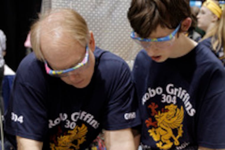 Mentor Joseph Robus helps out David Ryskalczyk, 18, ofGeorge Washington High School.
