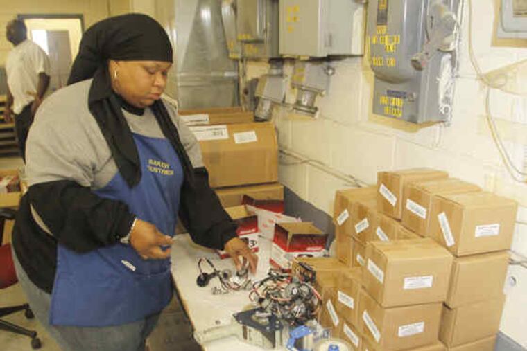 Harriet Nelson works at her station at Baker Industries, in Malvern, which specializes in hand assemblies and mailings.