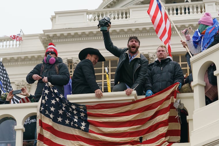 A supporter of President Donald Trump shouts while holding up a gas mask during the riot at the U.S. Capitol on Jan. 6.