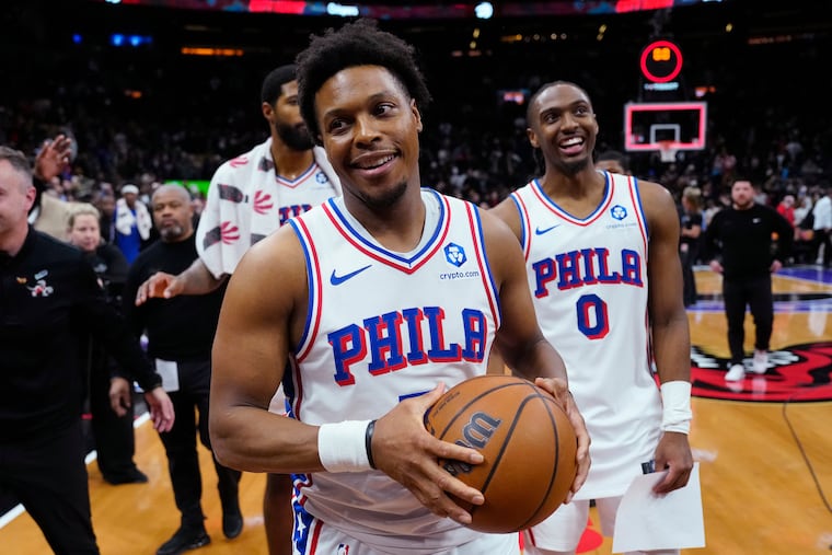 Sixers guard Kyle Lowry, front, holds the game ball after what could be his last game in Toronto, where the Raptors legend won an NBA title.