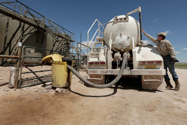 A worker empties oilfield wastewater from a tank truck into storage tanks on Carl and Justin Johnson's ranch near Crossroads, N.M. Labor shortages, supply problems and volatile prices have made oil companies cautious about new drilling even as U.S. politicians push for increased production.