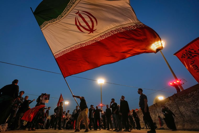 A man waves an Iranian flag during funeral ceremonies for slain Iranian Supreme Leader Ayatollah Ali Khamenei and members of his family at Imam Khomeini Mosalla Grand Mosque in Tehran, Iran, Sunday, July 5, 2026.