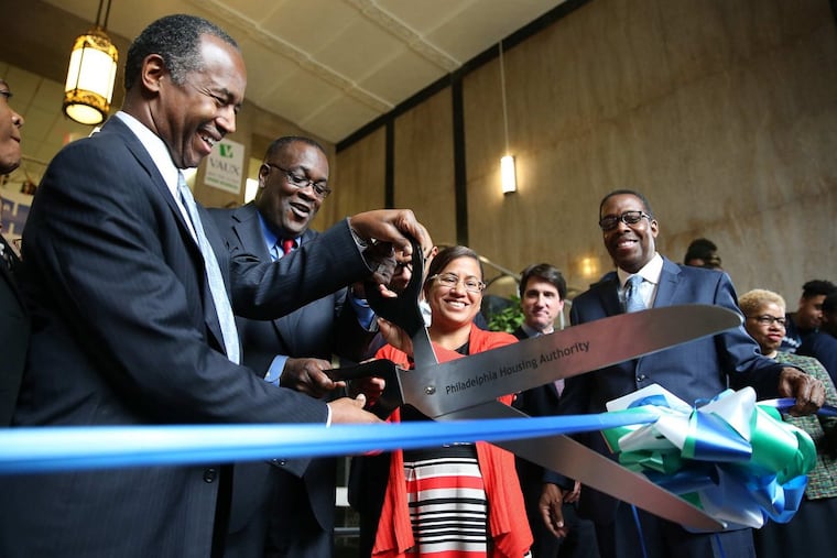 Housing and Urban Development Secretary Ben Carson (left) helps PHA president Kelvin Jeremiah (center) during the ribbon cutting at Vaux Big Picture High School in Philadelphia on Tuesday.