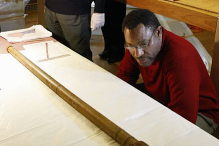 Derrick Pitts (right), chief astronomer of the Franklin Institute, and Giorgio Strano (not pictured), curator of Istituto e Museo di Storia della Scienza in Florence,
Italy (institute and museum of the history of science), inspect the last remaining telescope used by Galileo upon its arrival. (Stuart Watson / For the Inquirer)