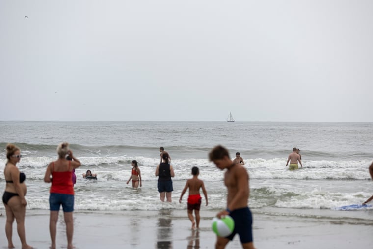 A boat is seen on the horizon as people enjoying the shore in Atlantic City on Tuesday, August 5, 2025.