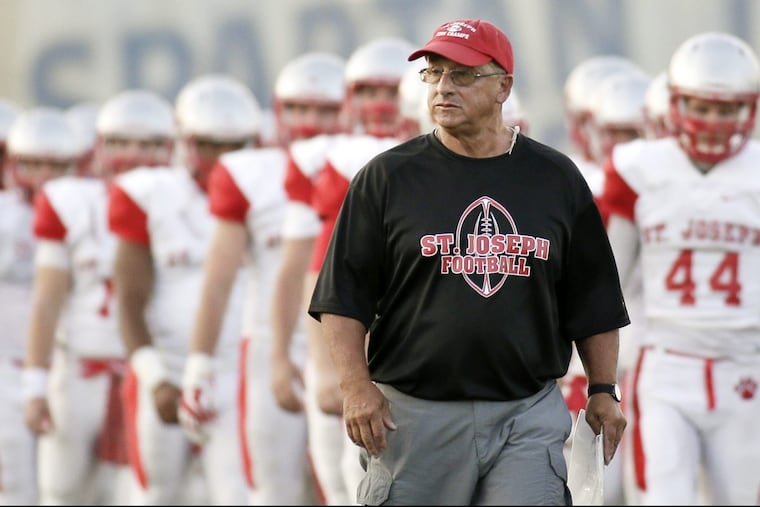 St. Joseph coach Paul Sacco leads his team to the field before facing Holy Spirit.