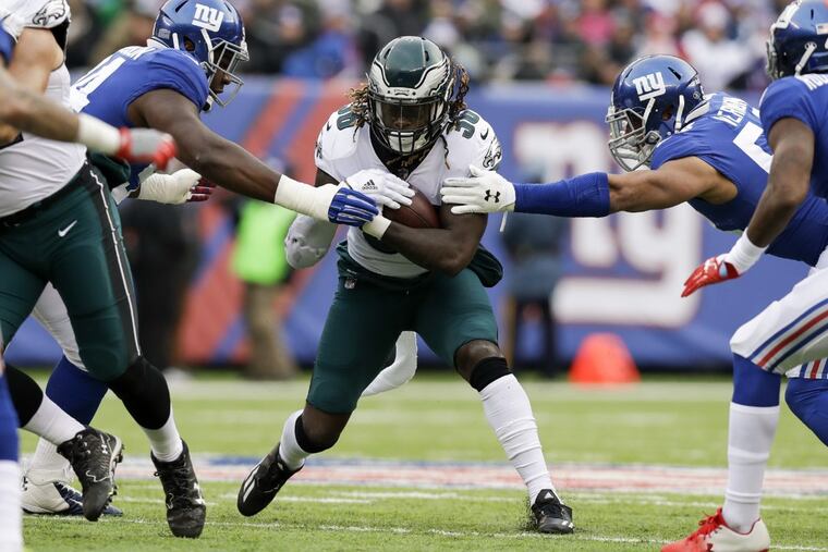 Jay Ajayi tries to get past Giants defensive end Olivier Vernon (left) and defensive tackle Dalvin Tomlinson (right).