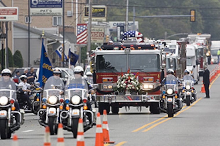 The fire-service procession for the burial of 19-year-old Michael
Reagan Jr. heads up Chester Pike.