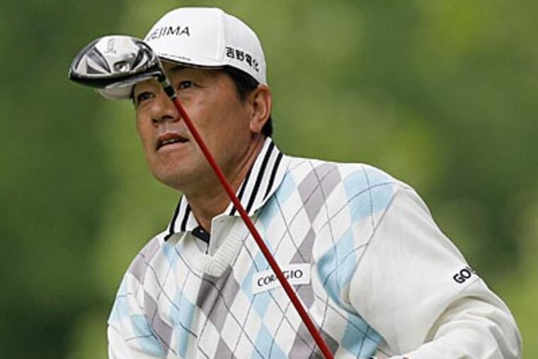 Kiyoshi Murota watches his tee shot on the second hole on Friday. (Ed Reinke/AP Photo)