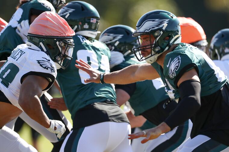 Eagles tight end Zach Ertz (right) runs a drill in practice. He'll look to break out of his slump Sunday against Baltimore.