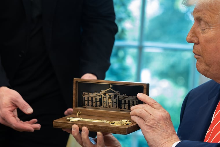President Donald Trump presents Elon Musk with a key to the White House on May 30.