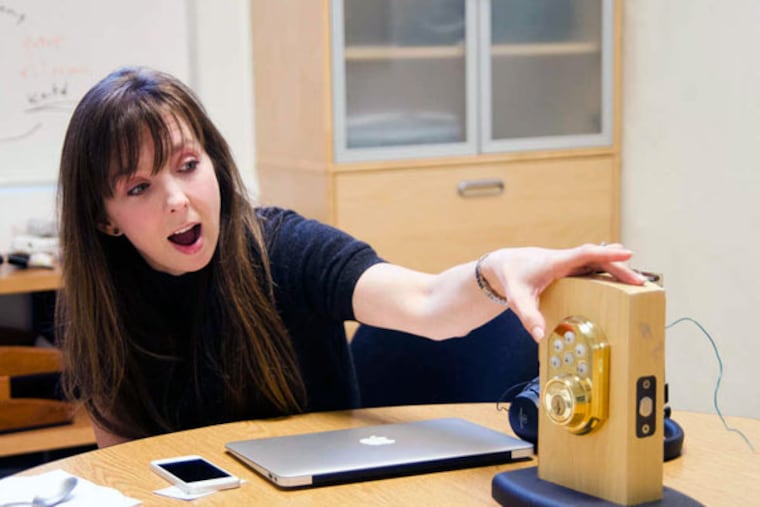 Felicite Moorman, CEO of BuLogics, demonstrates a wireless door lock, for which her firm created the technology. BuLogics' smart-home system allows various devices to connect to the Internet.