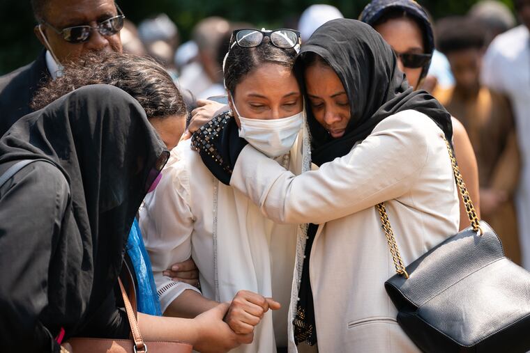 Lennora Mahmoud, center, stands at the grave of her son Salahaldin Mahmoud at Friends Cemetery in Upper Darby on Tuesday. Her son was killed during a cookout on the 4th of July in West Philadelphia.