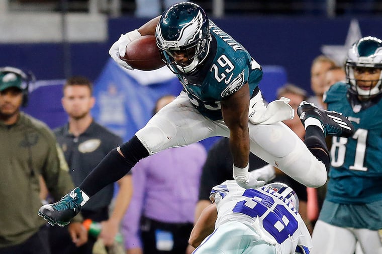 DeMarco Murray leaps over the Cowboys' Jeff Heath.