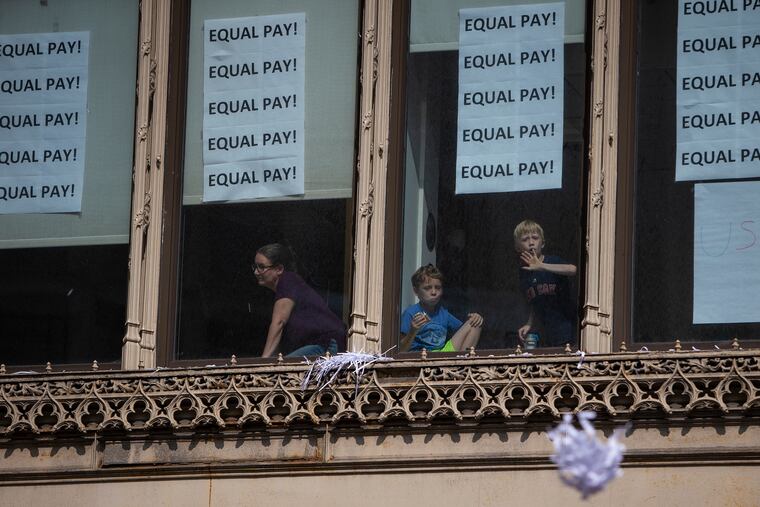 Kids react to confetti being thrown from a building with signs that read "Equal Pay" at Broadway and Park Row during the U.S. women's national soccer team championship parade down the Canyon of Heroes in lower Manhattan on Wednesday, July 10, 2019.