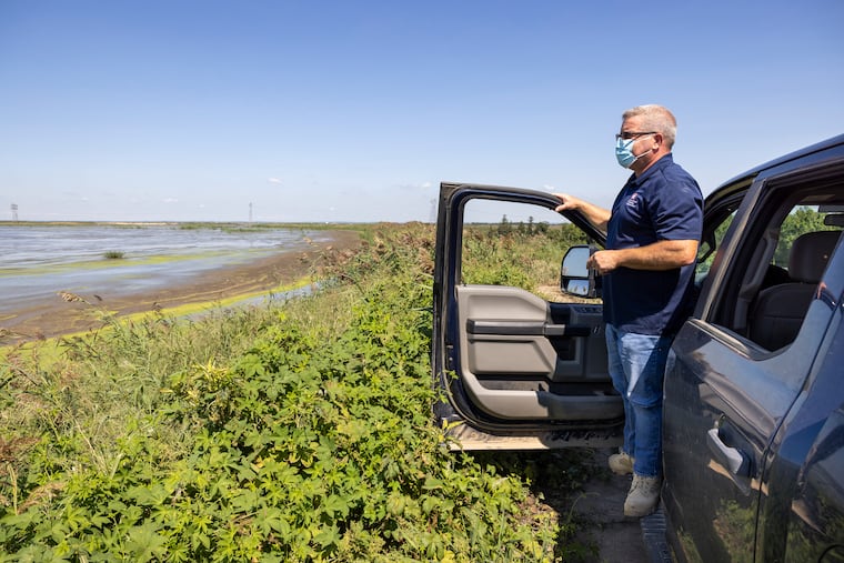 Tim Rooney of the U.S. Army Corps of Engineers stands on a piece of land on the Delaware River in Salem County, N.J., that is actually a part of Delaware. The land, created by the Corps dredging the river, was made part of Delaware by a centuries-old agreement.