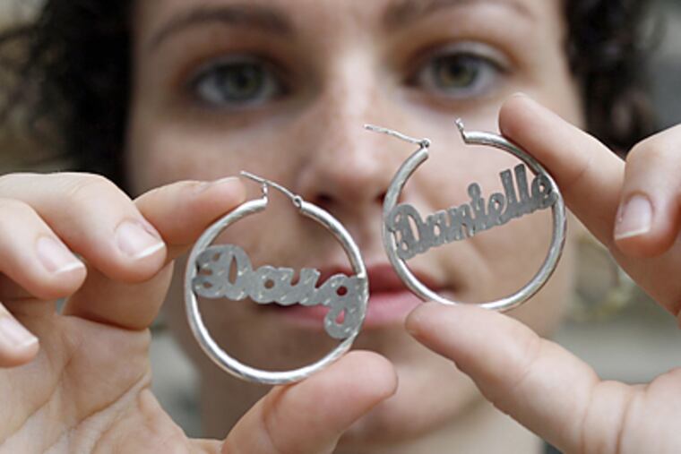 Danielle Hummel’s earrings bearing her name and that of a former flame are unwearable, but she's hesitant to sell them. (Bonnie Weller/Inquirer)