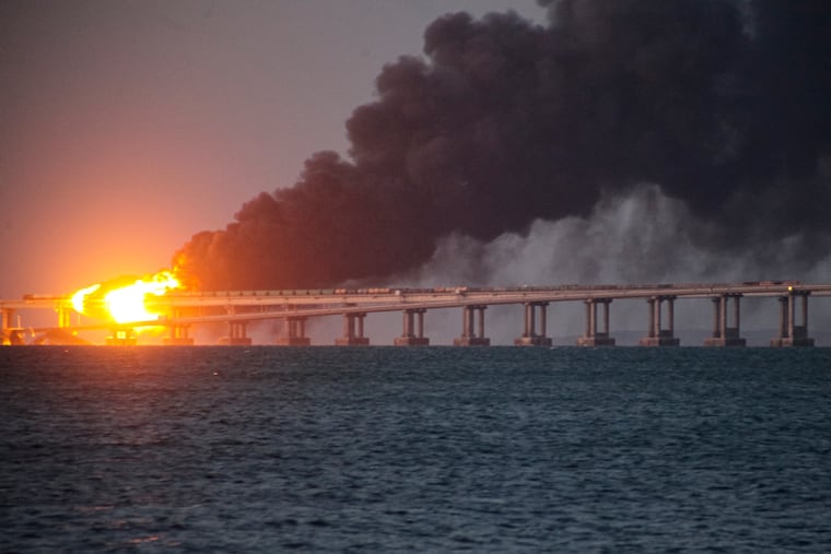 Flame and smoke rise from Crimean Bridge connecting Russian mainland and Crimean peninsula over the Kerch Strait, in Kerch, Crimea, in 2022.