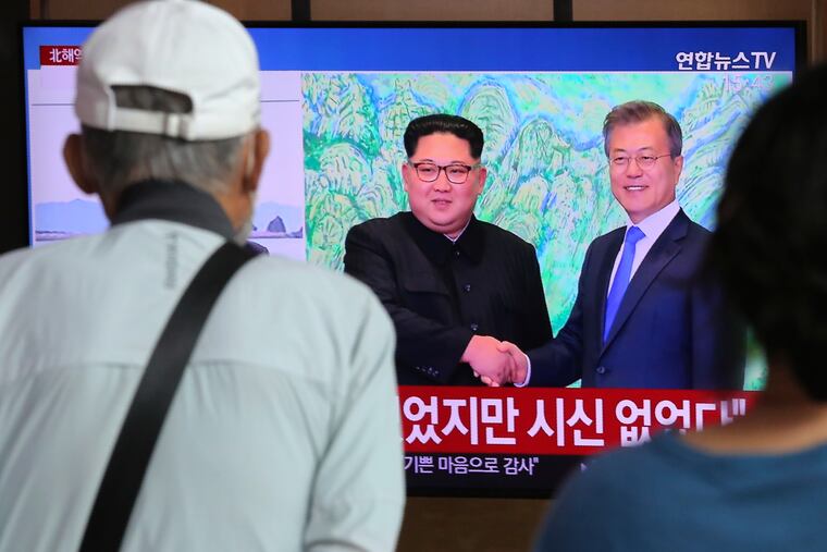 People watch a TV showing a file image of North Korean leader Kim Jong Un, left, and South Korean President Moon Jae-in during a news program at the Seoul Railway Station in Seoul, South Korea on Friday.