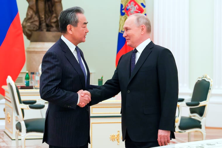 Russian President Vladimir Putin greets Chinese Communist Party's foreign policy chief Wang Yi during their meeting at the Kremlin in Moscow, Russia, on Wednesday.