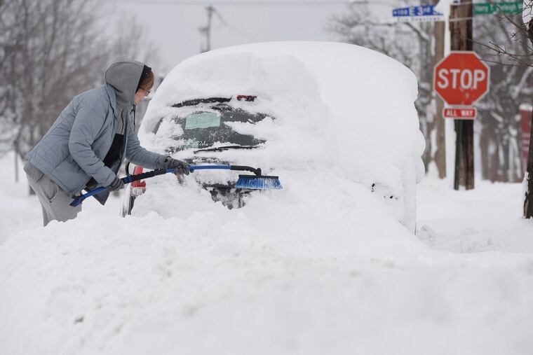 Chelse Volgyes clears snow from her car in Erie, Pa., Wednesday, Dec. 27, 2017.