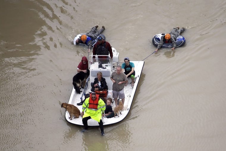 Evacuees make their way though floodwaters near the Addicks Reservoir as floodwaters from Tropical Storm Harvey rise Tuesday, Aug. 29, 2017, in Houston.