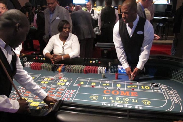 In this May 21, 2012, file photo, croupiers prepare to pay winning bets at a craps table at the Revel Casino Hotel in Atlantic City, N.J. Revel laid off 115 employees on Sept. 5, 2013, the same day the two Trump casinos in Atlantic City laid off 200 workers. The job cuts come as the East Coast gambling resort continues to struggle against competition in neighboring states, falling casino revenue and declining market share. (AP Photo/Wayne Parry)
