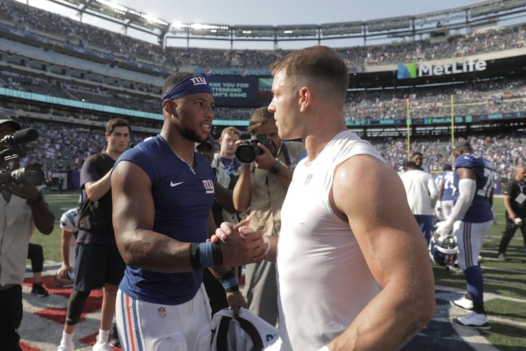 Then-Giant Saquon Barkley exchanges jerseys with then-Panther Christian McCaffrey after a game on Sept. 18, 2022.