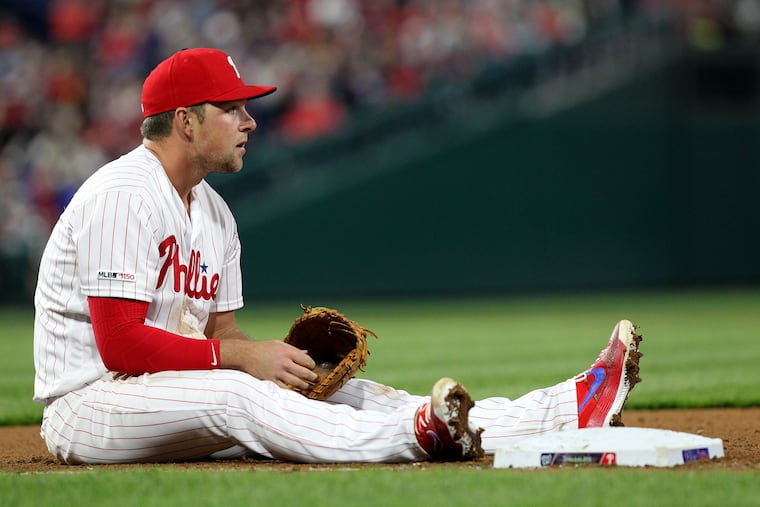 Rhys Hoskins of the Phillies sits on the ground after a Maikel Franco throwing error allowed Ryan Zimmerman of the Nationals to reach base in the seventh inning.