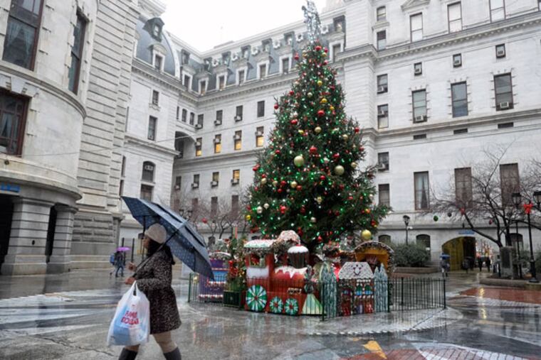 Rain and umbrellas were the order of the day on Christmas Eve in Center City and City Hall. (ED HILLE / Staff Photographer )