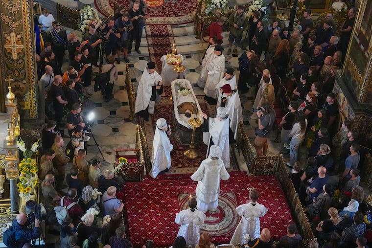 Priests preside over a farewell ceremony for Oleksiy Yukov, who was fatally wounded while exhuming bodies of killed soldiers in the frontline in Donetsk region, in St. Volodymyr Cathedral in Kyiv, Ukraine, Saturday, Aug. 8, 2026.