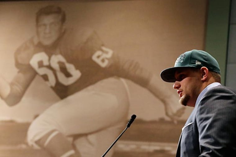 Philadelphia Eagles first round draft pick Lane Johnson speaks during an NFL football news conference at the team's practice facility, Friday, April 26, 2013, in Philadelphia. Johnson, an offensive tackle from Oklahoma, was selected fourth overall in Thursday's NFL draft. At left is a photo of former Eagles Chuck Bednarik. (AP Photo/Matt Slocum)
