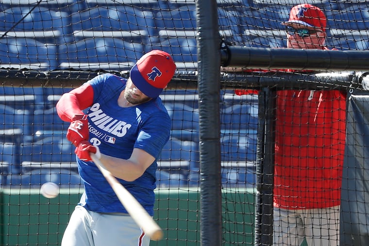 Charlie Manuel watches Bryce Harper take swings at batting practice on Sunday. Manuel and Larry Bowa, both former Phillies managers, are at spring training as instructors.