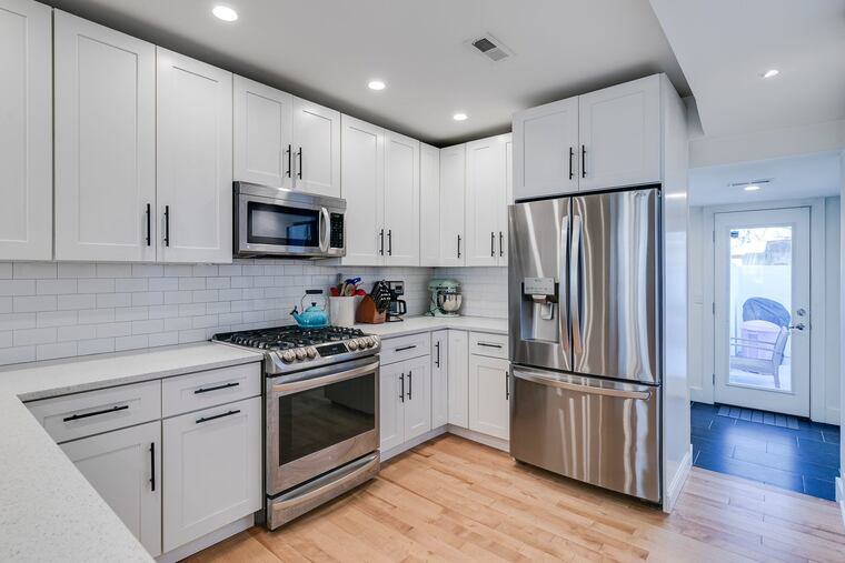 The kitchen has stainless steel appliances, quartz countertops, and an island.