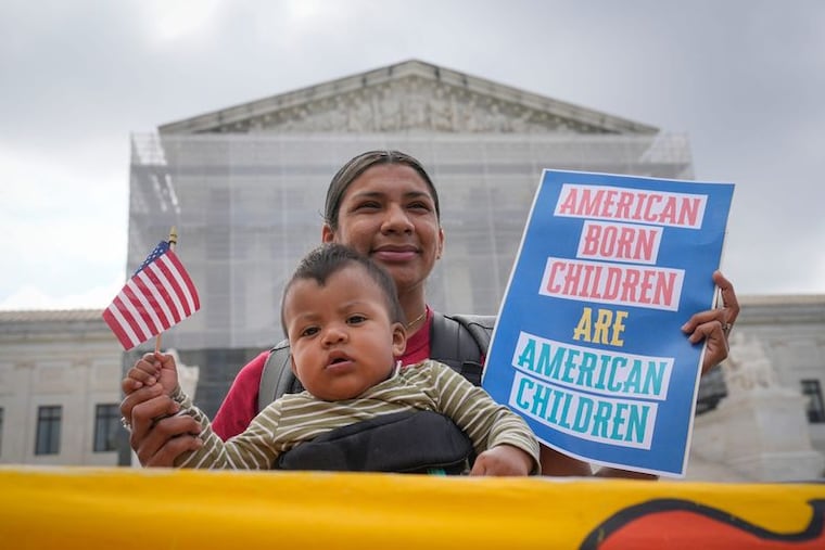 Olga Urbina and her child Ares Webster from Baltimore, MD, demonstrated outside the Supreme Court before justices heard oral arguments May 15 in the birthright citizenship case known as Trump v. CASA, Inc.