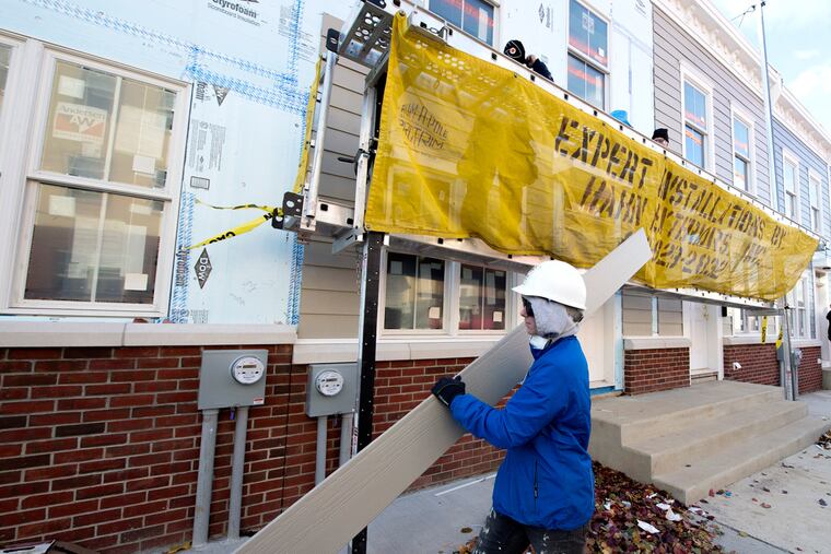 Rachel Taylor, an Americorps construction crew leader, carries a piece of siding at one of the 16 houses being built at the Habitat for Humanity worksite at 16th St. and Fontain St. in North Philadelphia November 21, 2016. Tools such as circular saws, nail guns, drills, power miter saws, tile saws and other tools used in building homes were stolen from the worksite on Halloween, putting in jeopardy the planned move-in dates of homeowners.