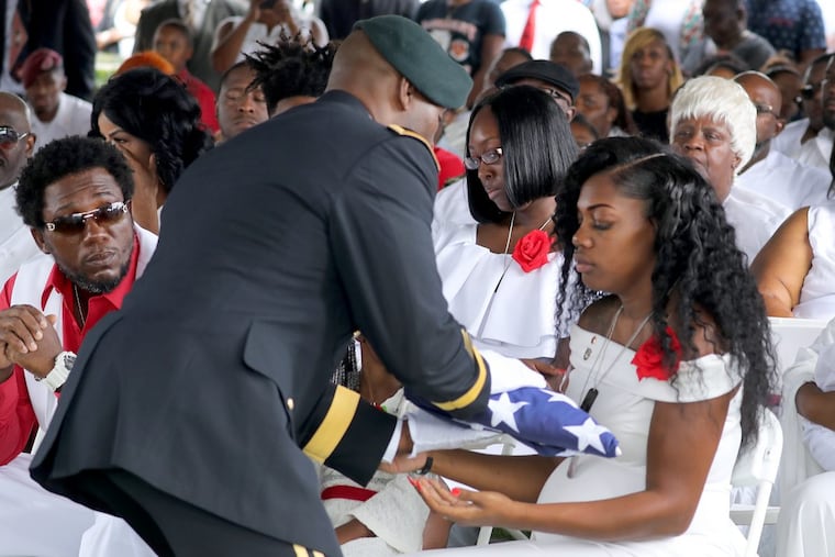 Myeshia Johnson, the wife of Army Sgt. La David Johnson, is presented a flag during his the burial at Hollywood Memorial Gardens in Hollywood, Fla., on Saturday, Oct. 21, 2017.